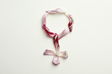 Female gender sign made of tulip petals on beige background, top view. Menopause concept