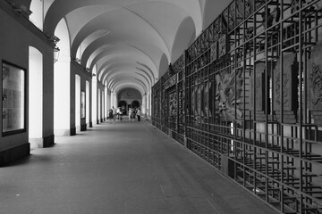 Una suggestiva foto in bianco e nero della cancellata del Teatro Regio di Torino con le volte e le colonne del porticato