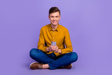 Photo of young man typing message social media post hold phone isolated on bright color background