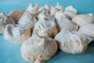 Homemade french milk-colored meringues on blue paper