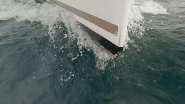 Sharp sailboat stern into the ocean in super slow motion
