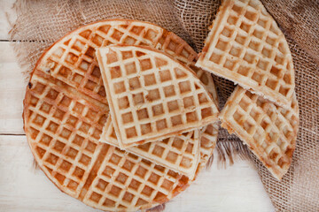 Plain waffles on rustic raw wood with burlap sack