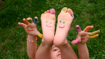 Child on the grass feet paint drawing. Selective focus. - Powered by Adobe