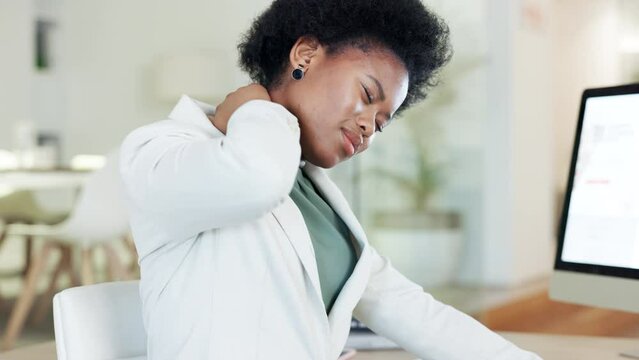 Woman suffering with neck pain from long working hours at desk in an office. Stressed female rubbing her stiff muscles and sore body while feeling strain, discomfort and hurt from bad sitting posture