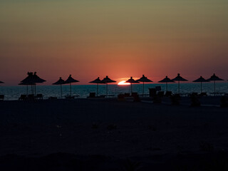 Parasols on an empty beach at sunset. Albania.