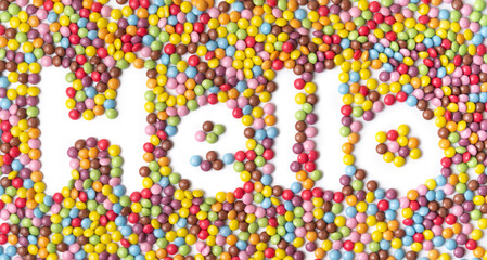 word HELLO. Multi-colored round candies on white backgrounds.
