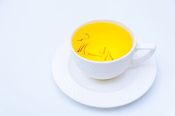 Obraz na płótnie Canvas Tea from saffron stamens in a white cup on a white background.