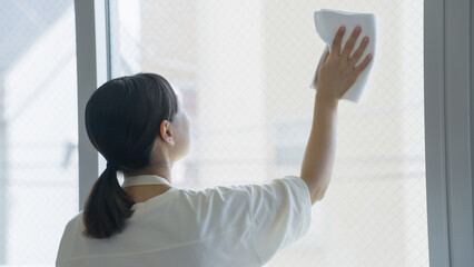 窓拭きをする女性（家事・掃除・主婦） © polkadot