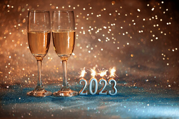Fototapeta 2023 Nowy Rok. Kartka z życzeniami szczęśliwego nowego roku 2023. kieliszki do szampana na brokatowy tle, new year obraz