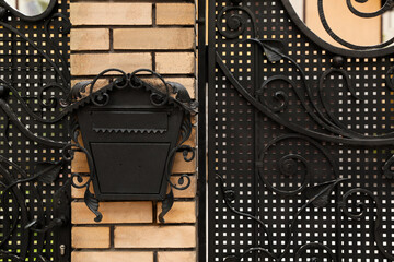 Vintage letter box on beige brick wall near fence outdoors