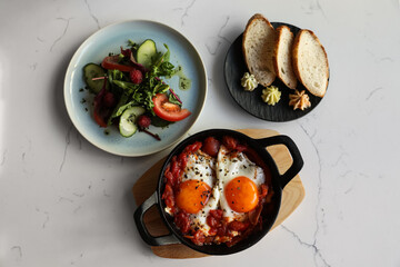 Tasty Shakshouka served on white marble table, flat lay