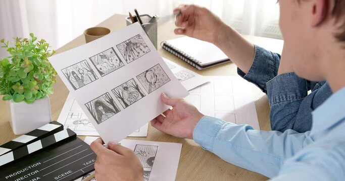 The director and cameraman examine the frames of the storyboard on paper. Drawn characters for the film. Storytelling concept.