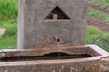Selective focus shot from opposite view of fountain located in rural area with iron tip.