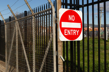 Sign with a red circle on a white background advising no entry is allowed, attached to an exite gate - 518520974