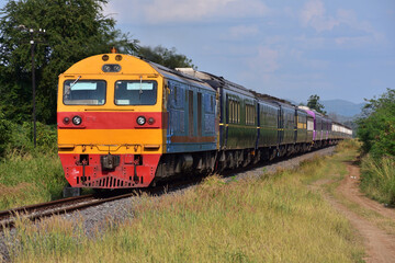 Naklejka premium Passenger train by diesel locomotive on the railway in Thailand