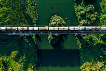 Aerial view of Railway railroad tracks and cargo train over the river