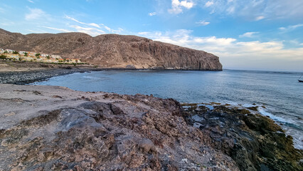 Peaceful evening at sunset on the seafront looking towards the cliffs at the eastern end of Los Cristianos, Tenerife, Canary Islands, Spain, Europe. View from lookout point Cypelek Los Cristianos