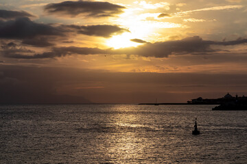 Romantic sunset over the sea in summer seen from lookout Cypelek Los Cristianos, Tenerife, Canary Islands, Spain, Europe. Vibrant colours of the clouds. Vacation vibes on the Atlantic Ocean. Awe