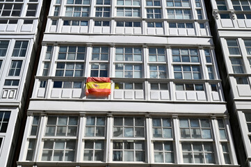 Façade d'un immeuble avec le drapeau espagnol accroché à une fenêtre