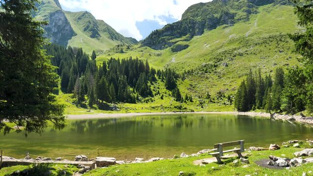 bench on a lake with alps mountain