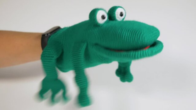 Knitted toy glove toad on a white background, a toy for the puppet theater. Close-up.