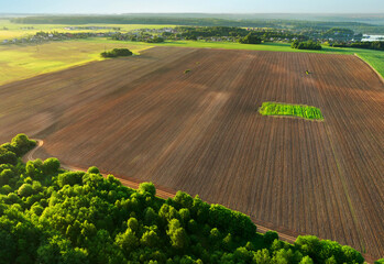 Agriculture fields, drone view. Arable land ploughed and soil Tillage. Field after cultivation, aerial view. Plowed field after harvest. Sowing seeds on a plantation. Soil cultivation.