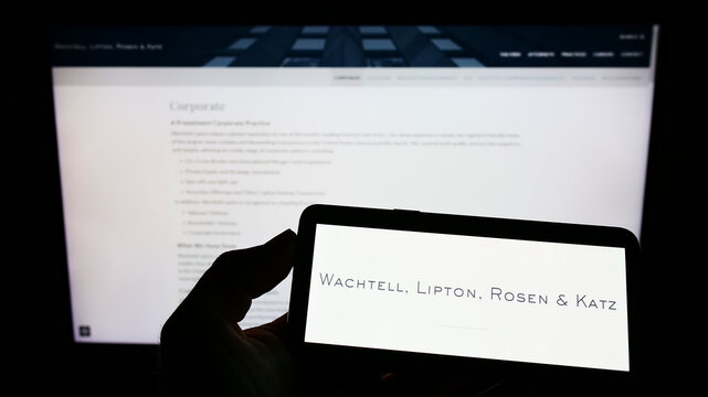 Stuttgart, Germany - 07-16-2022: Person holding mobile phone with logo of law firm Wachtell, Lipton, Rosen and Katz (WLRK) on screen in front of web page. Focus on phone display.