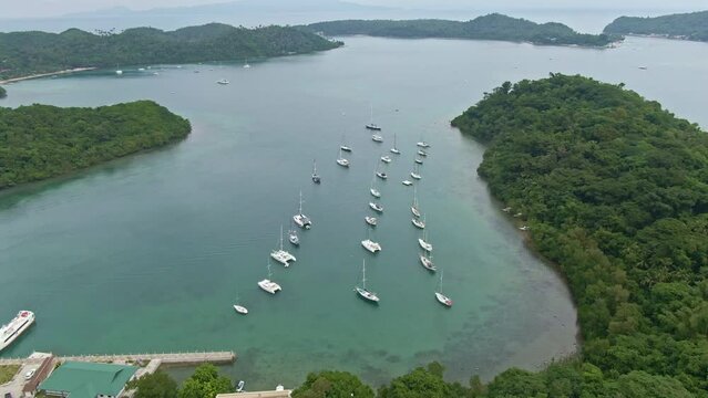 Beautiful view, aerial shot of yachts anchoring by the harbour, surrounded by the Islands from Puerto Galera, Philippines