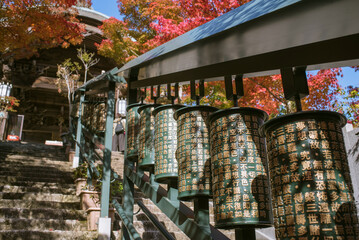 秋の広島県・宮島　大聖院の摩尼車と紅葉したもみじ　Prayer wheels and autumn foliage at Daisho-in Temple in Miyajima, Hiroshima, Japan