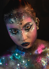 Creative make-up of a girl with rhinestones and piercing