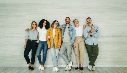 Multicultural businesspeople standing against a wall in an office