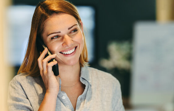 Happy Female Entrepreneur Speaking On A Phone Call