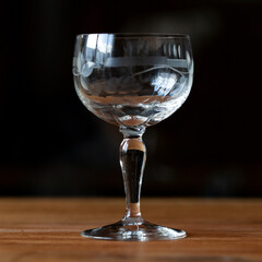 antique transparent glass wine glass on a black background. crystal glass with engraving. glass close-up