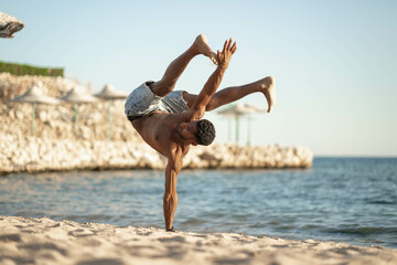 Handsome black young man topless dancing break dance, jumping, handstand, spinning, posing upside...