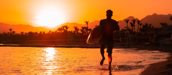 Banner Silhouette man surfer in sunset light running down beach with surfboard near waters edge enjoying summer time practice hobby during getaway vacations, guy recreating tropical island with waves
