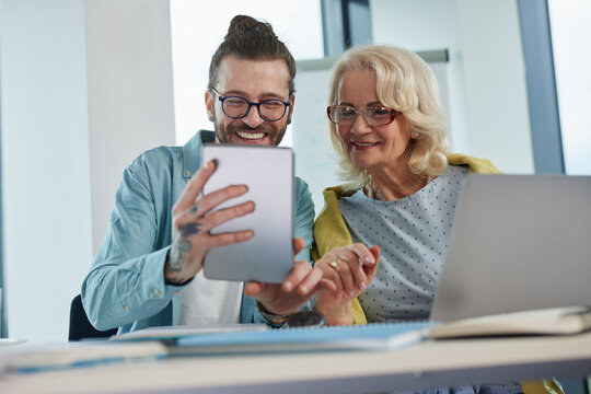 An educator helping female senior student to master the material.