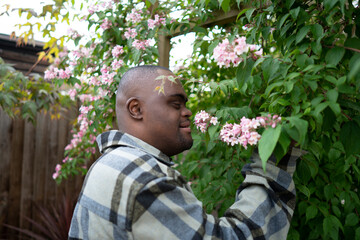 Man with Down syndrome smelling tree blossom