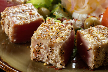 Seared ahi tuna with sesame seeds and soy sauce, wasabi, macro shot.