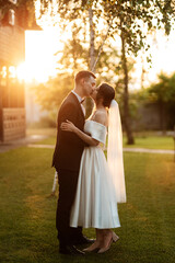 young couple the groom in a black suit and the bride in a white short dress