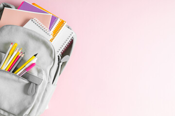 Back to school concept. Bright backpack with school stationery isolated on pink background. Flat...