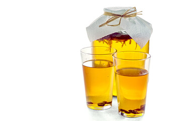 Jar of kombucha and two glasses of kombucha with raisins isolated on a white background on a light...