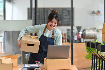 Startup small business, Young Asian women working with laptop and checking box delivery products to customers, Ordered online.