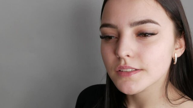 Young beautiful healthy girl model posing in the salon, smiling and rejoicing in front of the camera. Face without makeup, with long eyelash extensions before applying makeup