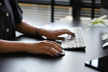 Close up with asian female'hand using mouse computer and typing on the keyboard.