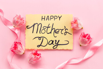 Layout of Happy Mothers day greeting card and pink flowers, top view