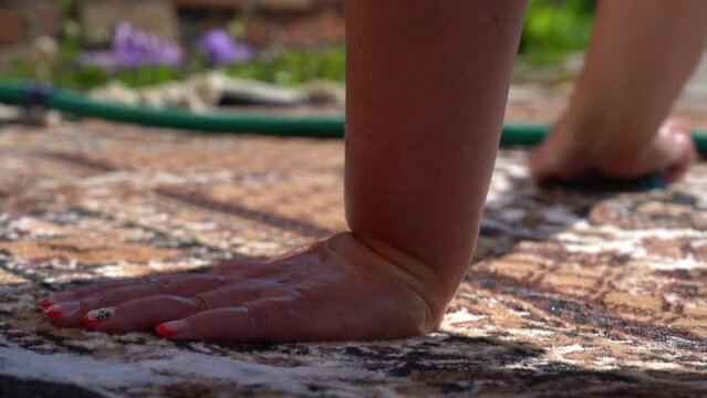 Woman manually washes the carpet . Hand wash the carpet. Carpet washing manually. Close-up