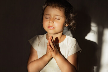 A little girl folded her hands in prayer in the hope of ending the war in Ukraine, a Ukrainian...