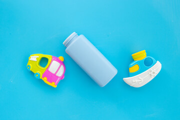 Talcum powder in container with kids toys. Baby care cosmetic