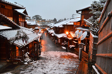 雪降る夜明けの京都市東山の二年坂を下る