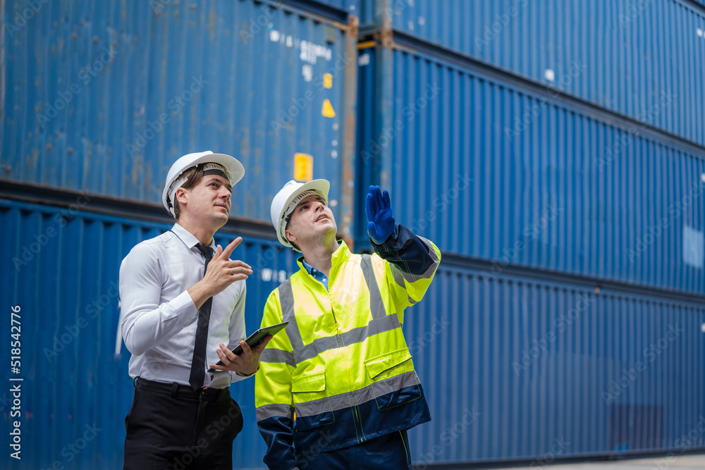 Poster Engineer and foreman team in hardhat checking stock into container for loading from cargo at container yard,Import export shipping concept.